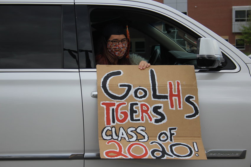 Mayah Baker holds a sign outside of her family's car. Many students came to the parade showing off their school pride.